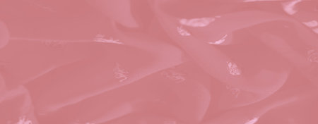 Blur of pink fabric displaying swirling folds with detailed white elephant motifs and floral...