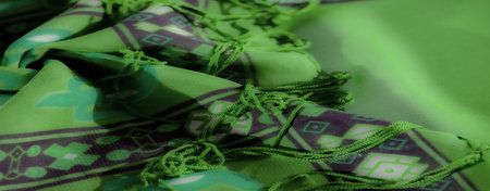 Blur - Close-up of a green textile featuring intricate swirling purple patterns, soft folds, and...