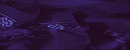 Blur, an artistic display of purple fabric with braided accents and a striking geometric background,...