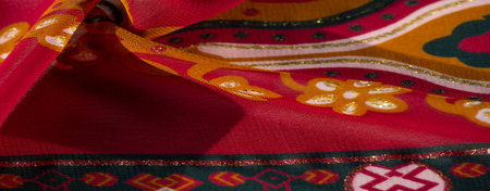 Blur - This vibrant fabric displays a red and yellow palette with geometric and floral details,...