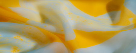 Blurred image of yellow and blue fabric folds in a dynamic and airy arrangement, with soft textures and vibrant hues for a captivating abstract design.の写真素材