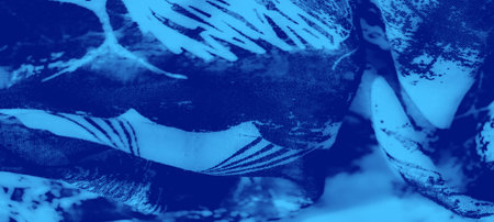 Blur of a blue fabric featuring intricate textures and patterns resembling abstract natural forms, with subtle light and dark contrasts.の写真素材