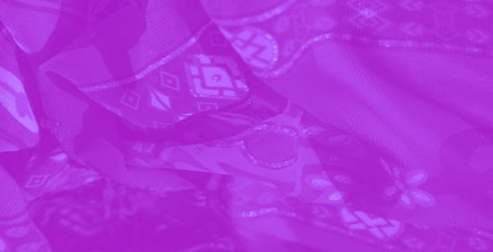 Blurred view of purple fabric with elegant floral motifs and abstract geometric shapes, emphasizing...