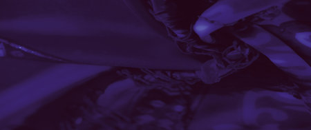 Blurred perspective of a vibrant purple fabric with ornamental details and shimmering threads, showing an artistic interplay of color and texture in textile design.の写真素材