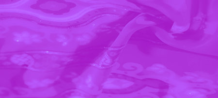 Blurred purple fabric displaying braided fringe with symmetrical floral and diamond-shaped designs, enhanced by soft textures and shimmering finishes for a refined aesthetic.の写真素材