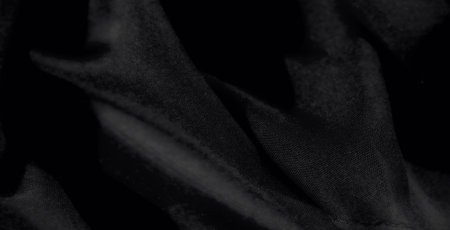 Blur of textured black fabric with fine details and subtle highlights, creating a seamless and stylish aesthetic for modern textile or design backdropsの写真素材