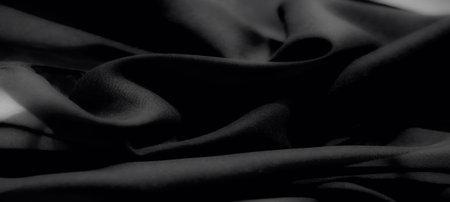 Blur the refined texture of soft black fabric with flowing folds and a modern matte finish, perfect for elegant, versatile, and creative design backgroundsの写真素材