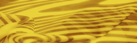 Blurred yellow fabric with an elegant abstract striped pattern, blending vibrant tones and smooth folds for a modern and artistic design suitable for decoration.の写真素材