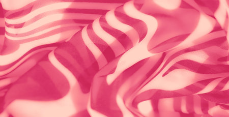 Blur of intricate pink fabric with a striped design, creating smooth curves and a dynamic, textured...