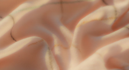 Blurred abstract close-up of soft pink fabric with brown and green grid-like patterns, gently twisted to showcase flowing folds and a smooth texture.の写真素材