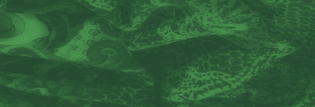 Blurred green fabric with an intricate floral paisley motif. Delicate patterns and a soft, luxurious texture make it perfect for artistic and design-oriented projects.の写真素材