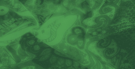 Blurred emerald-green fabric with a delicate blend of paisley and floral motifs, showing a luxurious design ideal for elegant backgrounds or fashion applications.の写真素材