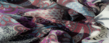 Blurred abstract depiction of fabric showcasing layered snake-skin textures in deep blue and gray...