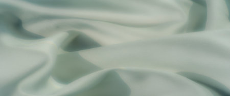 Blur of a soft draped mint green textile, showcasing gentle shadows and smooth folds, creating a calming and minimalistic composition perfect for any designの写真素材