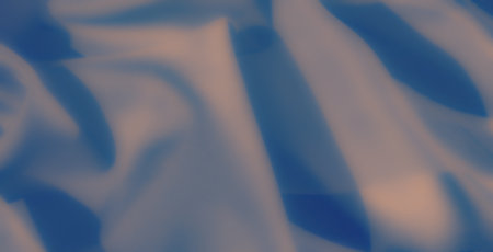 Blur, this image captures the soft, flowing textures of blue fabric, elegantly illuminated with subtle lighting that highlights its delicate folds and silky appearanceの写真素材