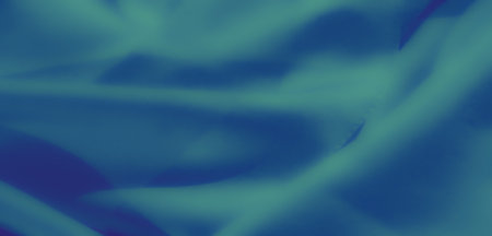 Blur of blue fabric captured in motion, showing delicate folds and gradients of light and shadow. A visually appealing and artistic textile abstract.の写真素材