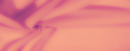 Blur effect on a smooth, folded fabric with a mix of pink and peach hues, creating a gradient-like soft texture that feels luxurious and delicate. Perfect for backgrounds and design.の写真素材