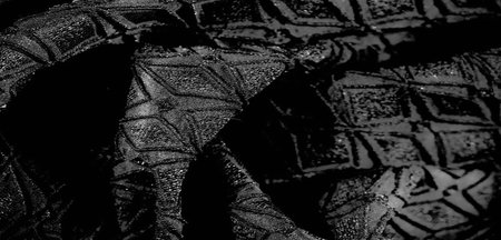 Blur A detailed close-up of black fabric with geometric patterns. The fabric's smooth folds enhance...