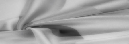 Blur - Elegant grayscale fabric draped in a soft, flowing swirl with smooth textures, creating a serene and modern look.の写真素材