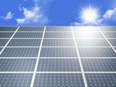 Blue solar panel system produces alternative green energy from the sun against cloudy blue sky.