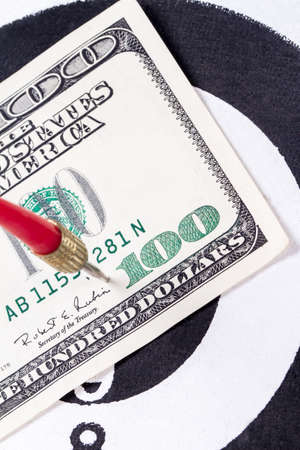 Red arrow and one hundred dollar bill on dart board.の写真素材