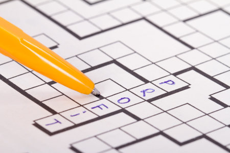 Close up of blank square crossword puzzle with pen and profit text.の写真素材