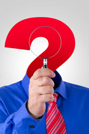 Businessman with red question mark head holding and showing magnifying glass.の写真素材