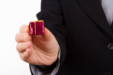 Business woman extends red gift box with yellow rope, isolated on white background.の写真素材