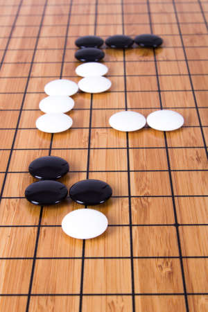 Close up view of black and white stone pieces on Chinese go game board.の写真素材