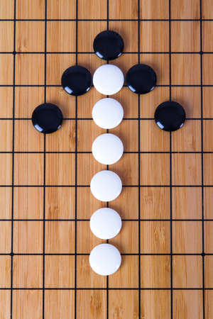 Top view of black and white Chinese go game pieces, up direction arrow shape.の写真素材