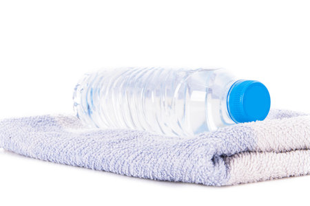Plastic water bottle on blue striped towel, isolated on white background.の写真素材
