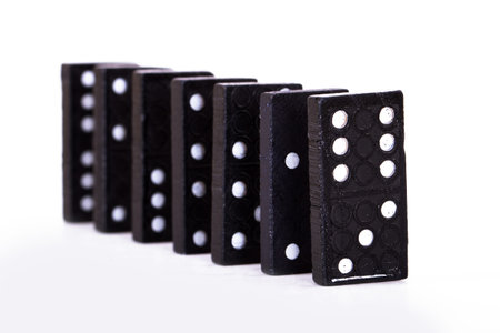 Row of black dominoes, isolated on white background.