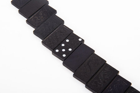 Line or row of black dominoes, isolated on white background.