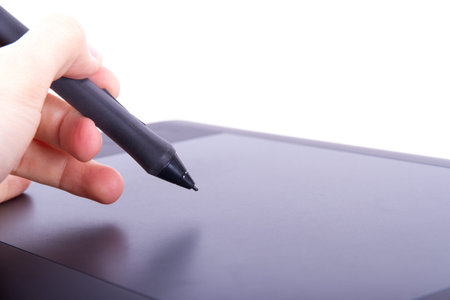 Illustrator or artist hand holding digital pen on graphic tablet, isolated on white background.