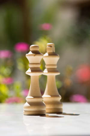 Chess pieces, queens on white table with blurry background.の写真素材