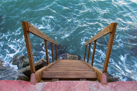 Wavy sea and stairs at the coast.の写真素材