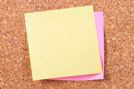 Blank, empty, yellow sticky post it note for your message on cork bulletin board.の写真素材