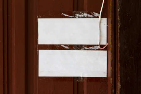 Blank, white, taped papers on wooden wall.の写真素材