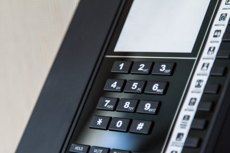 Telephone for service with blank white note area in hotel room.の写真素材