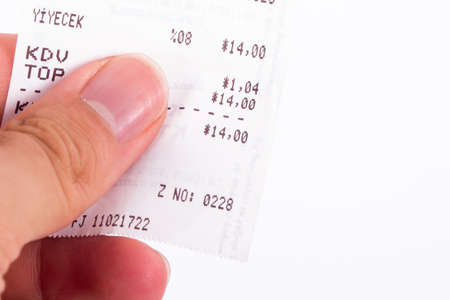 Close up view of hand holding cash register receipt, isolated on white background.の写真素材