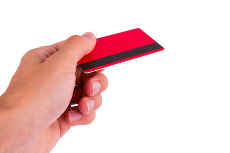 Hand holding red credit card, isolated on white background.の写真素材