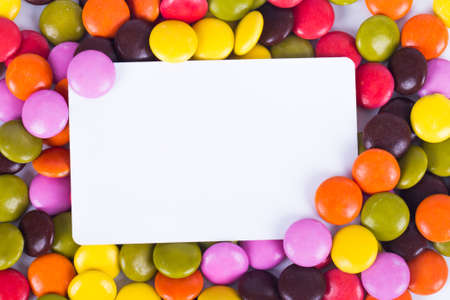 White, blank card with colorful sugar candies.の写真素材