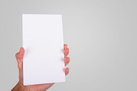 Hand holding and showing white cardboard.