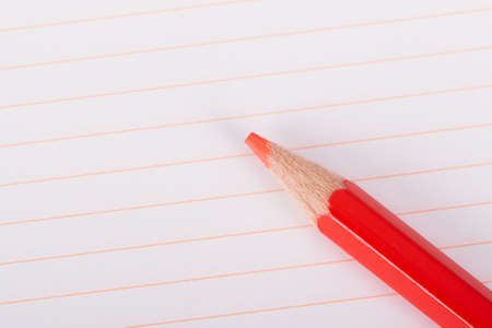 Red pencil on blank, white, lined notebook with copyspace.の写真素材