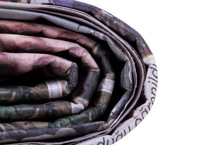 Corner of stacked newspapers, isolated on white background.の写真素材