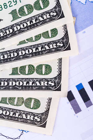 One hundred dollar banknotes on chart graphs.の写真素材