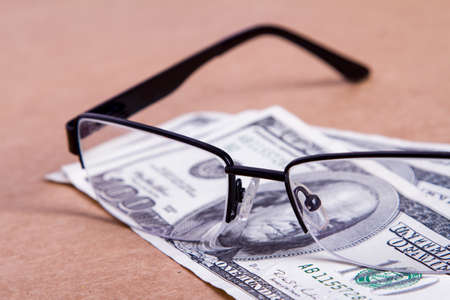 Pair of eyeglasses on one hundred dollar banknotes.の写真素材