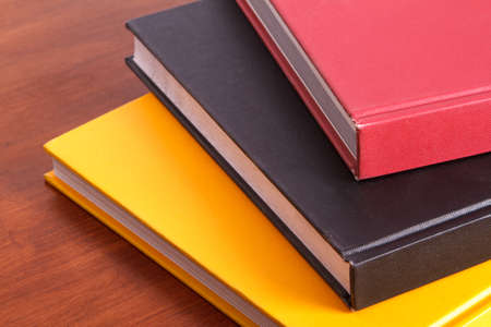Stack of colorful books on wooden table.の写真素材