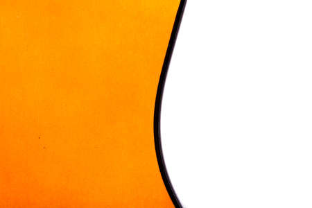 Detail view of orange wooden classical acoustic guitar, isolated on white background.の写真素材