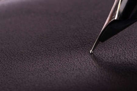 Close up view of seamless black leather texture with fountain pen.の写真素材